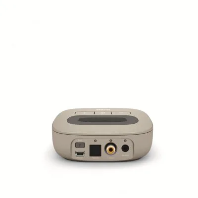 A beige rectangular Phonak TV-Link II Base, shown from the back, features labeled ports—Pair, Optical, Coaxial, Analog—a power button, and the brand name on top.